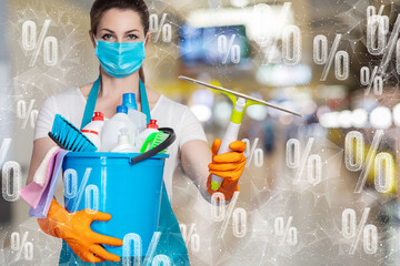 A cleaning lady in a mask stands with cleaning tools against the background of flying percentage .