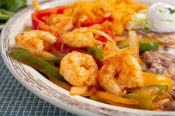A view of a plate of shrimp fajitas, in a restaurant or kitchen setting.