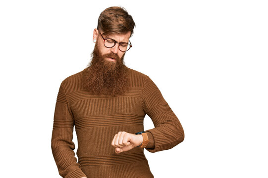 Young irish redhead man wearing casual clothes and glasses checking the time on wrist watch, relaxed and confident