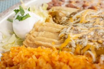 A closeup view of a plate of tamales, in a restaurant or kitchen setting.