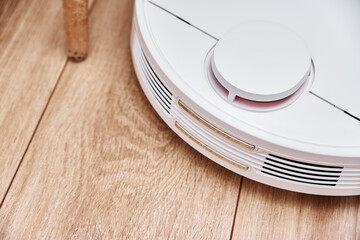 Robot vacuum cleaner working on floor with furniture, obstacles for robotic vacuum cleaner. Modern smart household