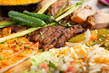 A view of a Latin American food platter, featuring chopped carne asada and pollo asado.