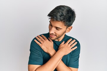 Young handsome man wearing casual clothes hugging oneself happy and positive, smiling confident....