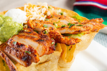 A view of a chicken taco salad, in a restaurant or kitchen setting.