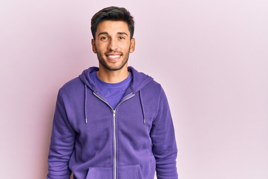 Young handsome man wearing casual sweatshirt with a happy and cool smile on face. lucky person.