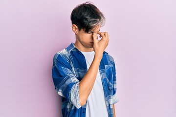 Young hispanic man wearing casual clothes tired rubbing nose and eyes feeling fatigue and headache. stress and frustration concept.