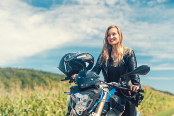Beautiful woman on a motorcycle looking at the road ahead - 394428029