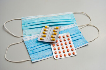 Two different plates with multi-colored pills lie on two masks.