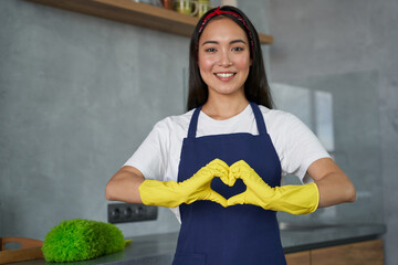 Love to Clean. Cheerful young woman, cleaning lady wearing protective gloves, smiling at camera,...
