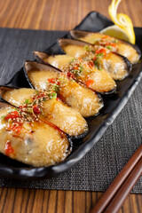 A view of an appetizer platter of baked green mussels.