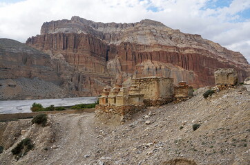 Buddhist chortens and ruins against the background of mountains, on the way to Chusang.  Upper...