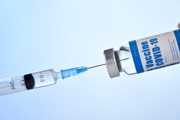 Syringe taking covid 19 corona virus liquid vaccine dose from vial bottle testing, preparing for...