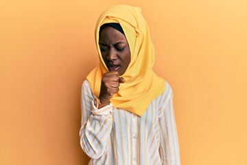 Beautiful black woman wearing traditional islamic hijab scarf shouting and screaming loud to side with hand on mouth. communication concept.