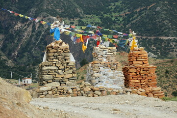 Ancient Buddhist chortens are adorned with colorful flags in the mountains of the Upper Mustang...