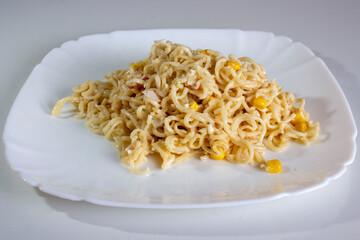 Pasta with corn on a plate.