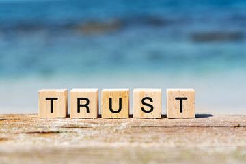 Trust text on wooden block at the beach