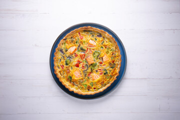 Traditional salmon quiche with broccoli and vegetables