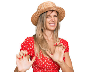 Beautiful caucasian woman wearing summer hat disgusted expression, displeased and fearful doing...