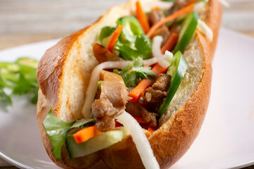 A closeup view inside a chicken banh mi sandwich.