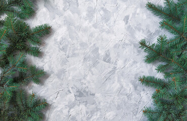 Christmas gray grunge background, fir twigs, top view. Winter holidays, New Year decoration, pine tree branches vertical both sides on light concrete, rough cement texture, flat lay, copy space.