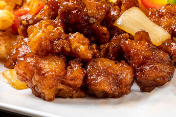Close up view of Chinese food,  General Tso or orange chicken on a white plate