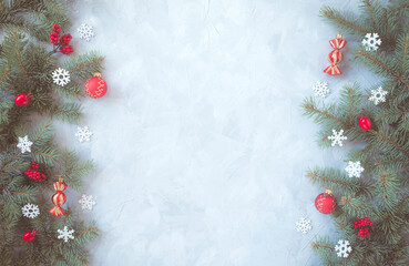 Naklejka na ściany i meble Christmas gray grunge background, fir twigs, berries, snowflakes and baubles, top view. New Year decoration, pine tree branches, cones vertical both sides on light concrete rough texture, copy space.