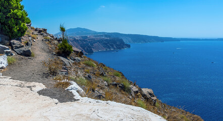 Fototapeta na wymiar A view of the path from Skaros Rock along the rim of the caldera in Santorini in summertime