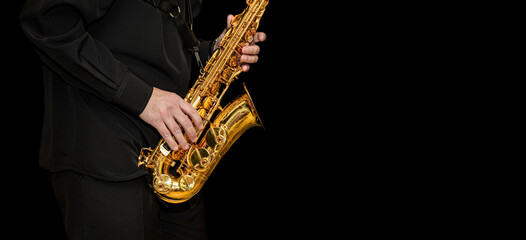 Obraz na płótnie Canvas Saxophone with disperse dust effec Player hands Saxophonist playing jazz music. Alto sax musical instrument closeup on black background with place for text