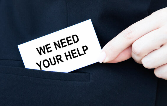 A businessman puts a card with text in the pocket of WE NEED YOUR HELP.