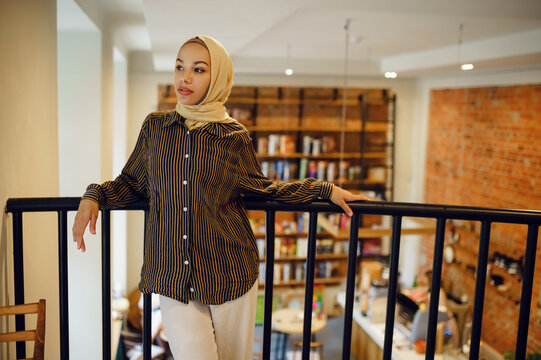 Beautiful arab girl in hijab in university cafe - Powered by Adobe