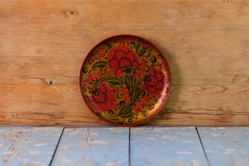 Fototapeta na wymiar round painted dish on old wooden background