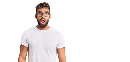 Young hispanic man wearing casual clothes and glasses afraid and shocked with surprise and amazed...