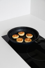 Step-by-step recipe - Curd pancakes are frying in a black pan