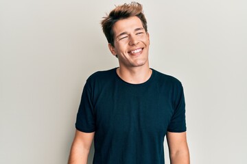 Handsome caucasian man wearing casual clothes looking to side, relax profile pose with natural face and confident smile.