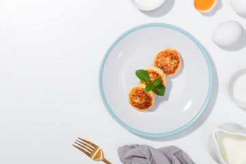 Step-by-step recipe - Cottage cheese, eggs, cream and yougurt on a white background - Flat lay with curd pancake