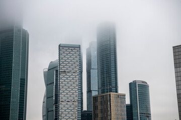 cityscape with high-rise buildings whose upper floors have melted into fog