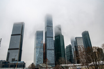 cityscape with high-rise buildings whose upper floors have melted into fog