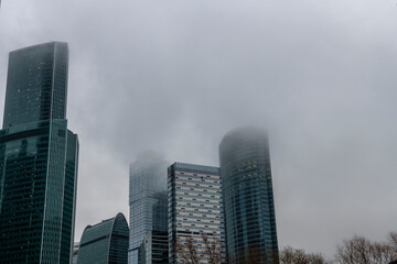 cityscape with high-rise buildings whose upper floors have melted into fog