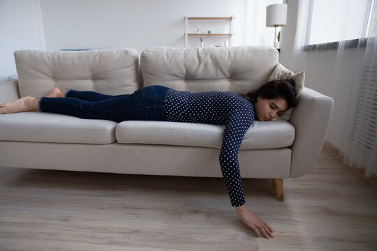 Tired Asian Woman Sleeping On Couch At Home, Taking Day Nap, Feeling Lack Of Energy After Sleepless Night Or Hard Workday, Exhausted Female Resting On Cozy Sofa In Living Room Alone, No Motivation