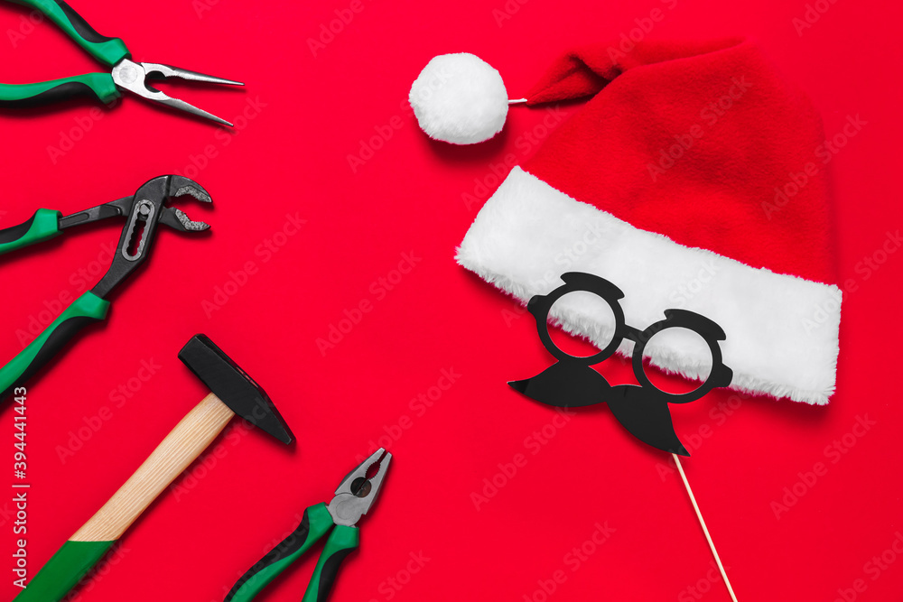 Wall mural A set of quality green building tools to repair a car or house and santa claus hat on a red background. Do it yourself instruments. Banner for a Christmas advertise construction shop with copy space