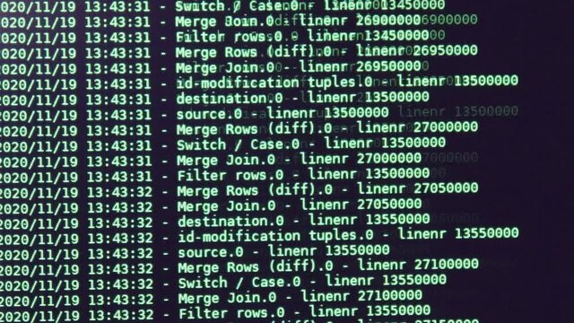 Green computer software code moving on a black monitor. Computer hacking in process, dynamic text running and flowing on pc screen.