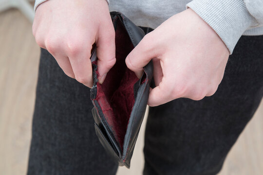 An empty wallet with no money in the hands of a person.