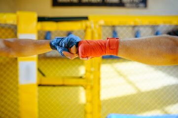 Male MMA fighters hands with red and blue bandages
