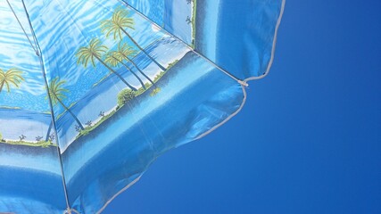 Fototapeta na wymiar Palma de Mallorca, Spain, August 17, 2014: Blue parasol detail on blue sky