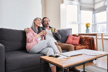 Man and woman sitting on sofa and bonding to each other