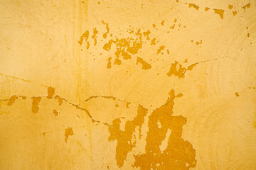 Yellow wall with old cracked paint.