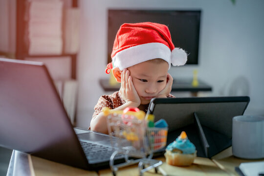 An Asian Boy Is Bored Watching Multimedia From His Tablet Screen At Home During The Christmas Holidays.