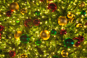 Obraz na płótnie Canvas A close up of a Christmas tree with lights and ornaments at night.