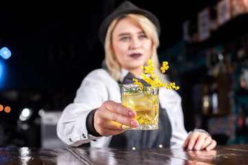 Girl barman makes a cocktail on the saloon