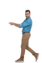 casual attractive man walking and pointing one way